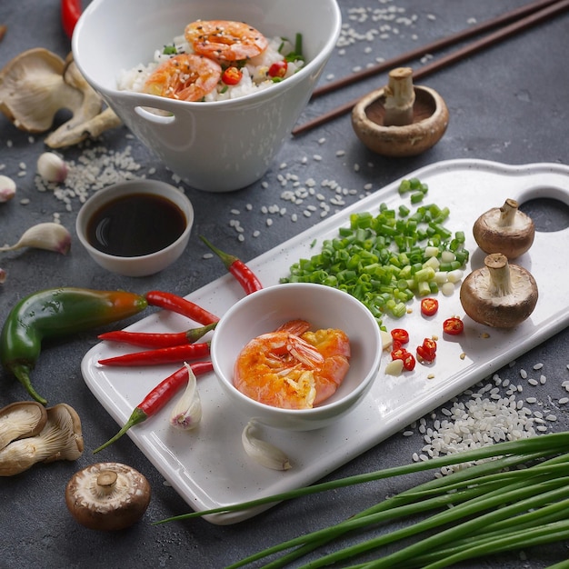 Asian food on a dark background, During preparation, Wok rice with shrimps and mushrooms