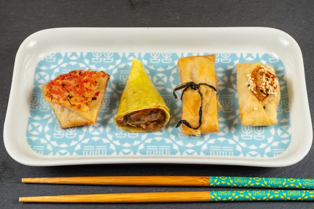 Asian food selection.Duck cones,parcels,baskets with ginger and soy sauce,tikka crackers, windmills