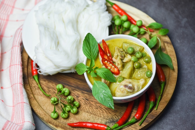 Asian food on the table. Thai food green curry chicken on soup bowl and thai rice noodles vermicelli with ingredient herb vegetable