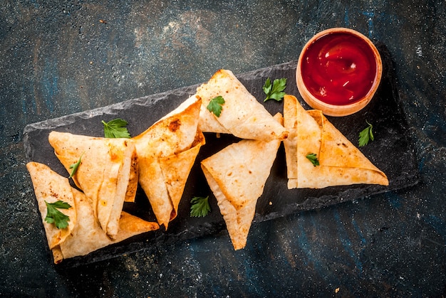 Asian food. Vegetarian samsasamosas with tomato sauce. Dark blue   top view