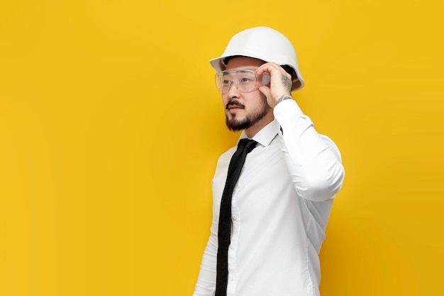 asian foreman in shirt with tie stands on yellow isolated background korean civil engineer