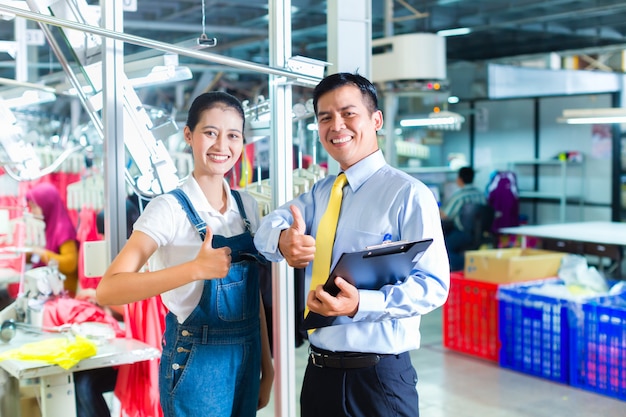 Asian foreman in textile factory giving training