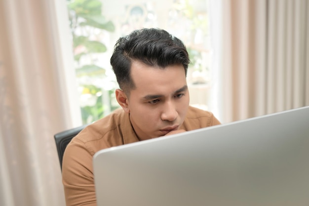 Asian freelancer man is thinking and working on his computer Concept of freelance creative works