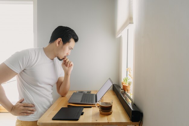L'uomo d'affari libero asiatico sta pensando e sta lavorando al suo computer portatile