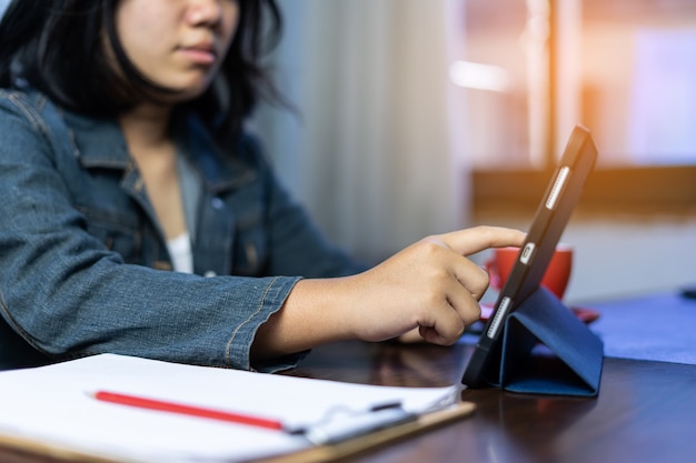 Libero professionista asiatico che utilizza la videoconferenza di lavoro su tablet con un cliente in ufficio a casa. marketing e finanziario. trattare con i clienti tramite app online. vendita e ricezione ordini online. lavoro da casa.