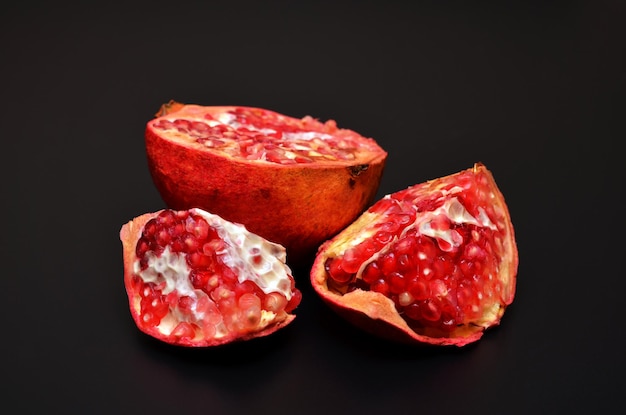 Asian fruit red pomegranate with seeds on a black close up