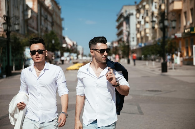 Asian gay couple is walking on the street looking at the sights having nice time together Well fashion dressed