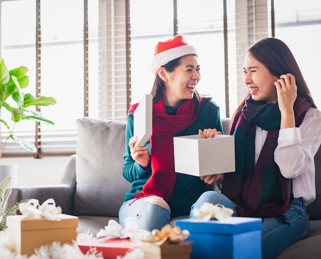 Asian girl best friends excited and surprised opening present gift box