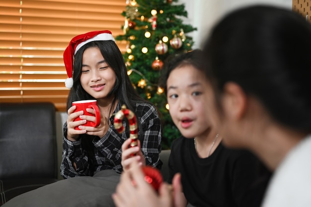 Ragazza asiatica che celebra il natale con i suoi amici a casa.