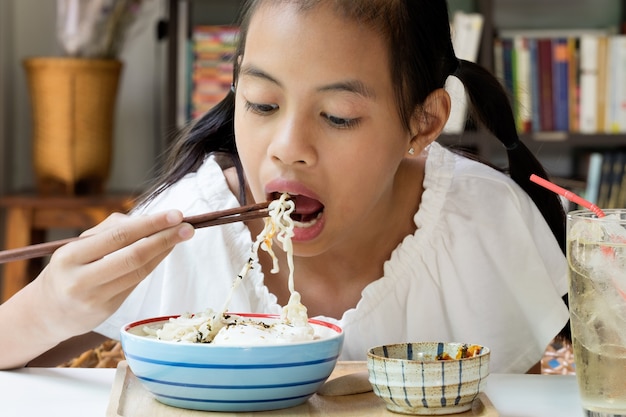 インスタント韓国ヌードを食べるアジアの女の子