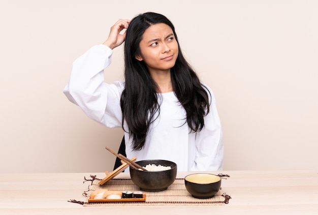 Азиатская девушка ест лапшу за столом