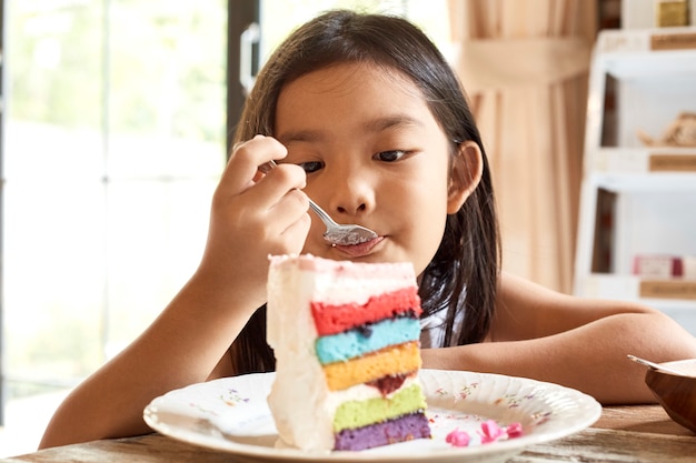 アジアの女の子、カフェでケーキを食べる。