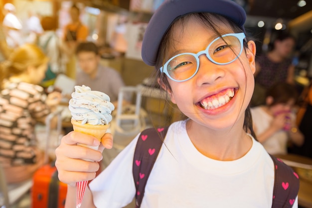 그녀의 아이스크림을 즐기는 아시아 소녀