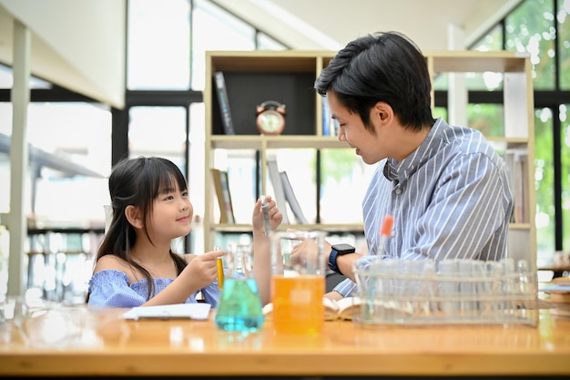 asian girl enjoys learning science doing some science experiment with her teacher