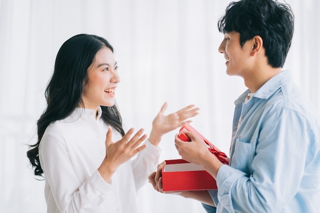 La ragazza asiatica si sente felice e sorpresa di ricevere regali dal suo ragazzo il giorno di san valentino