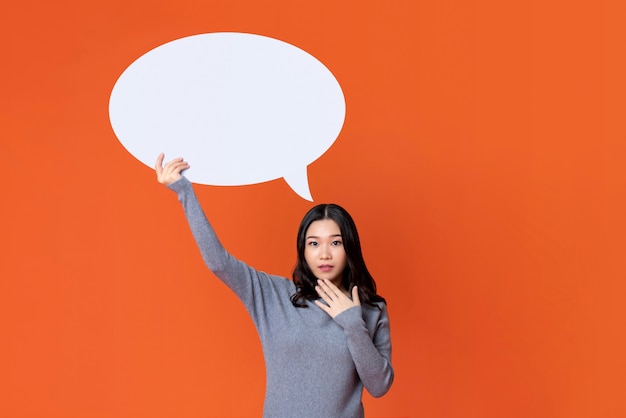 Asian girl in gray t-shirt holding empty speech bubble