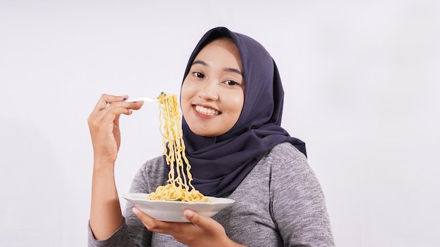 Asian girl happily enjoying noodles isolated on white background