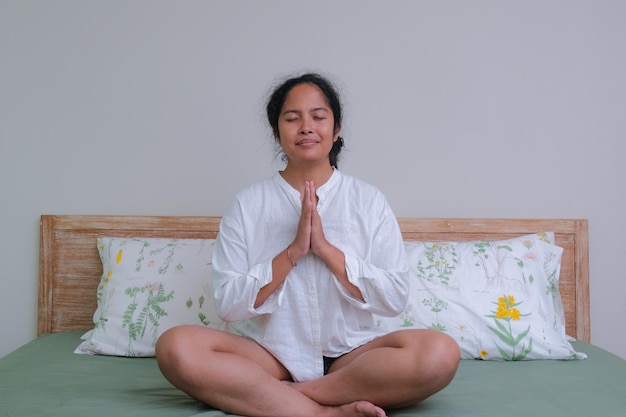 Asian girl in her yoga position in bed