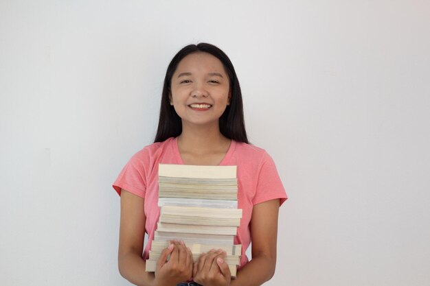 아시아 소녀 whiye 배경에 그녀의 팔에 책을 들고 학생 소녀