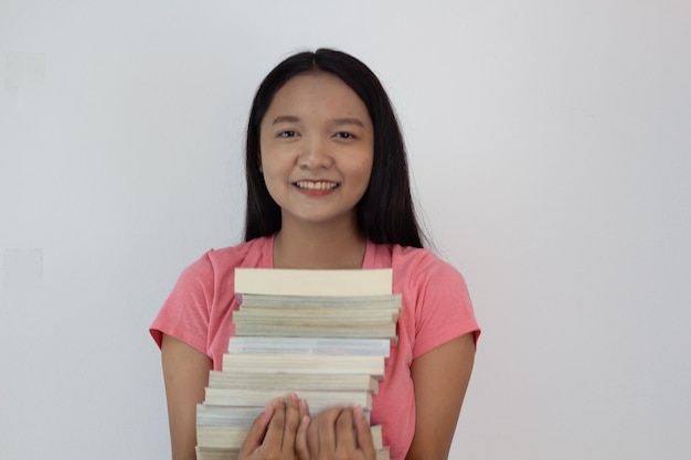 Photo asian girl hold book on her arm on whiye backgroundstudent girl