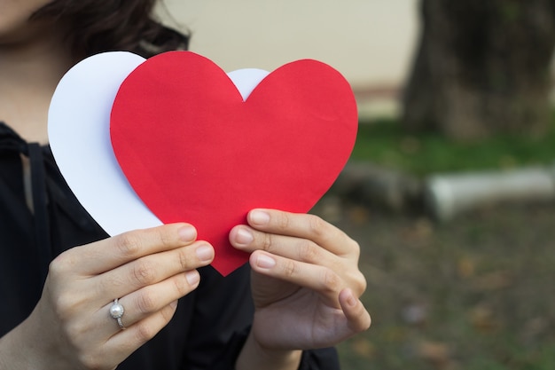 Foto cuore asiatico della tenuta della ragazza rosso e bianco, concetto di amore