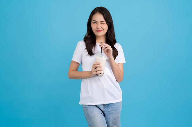 Азиатская девушка держит чашку чая с жемчужным молоком с улыбкой веселья и счастья