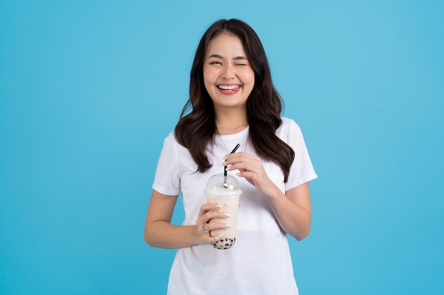 Азиатская девушка держит чашку чая с жемчужным молоком с улыбкой веселья и счастья