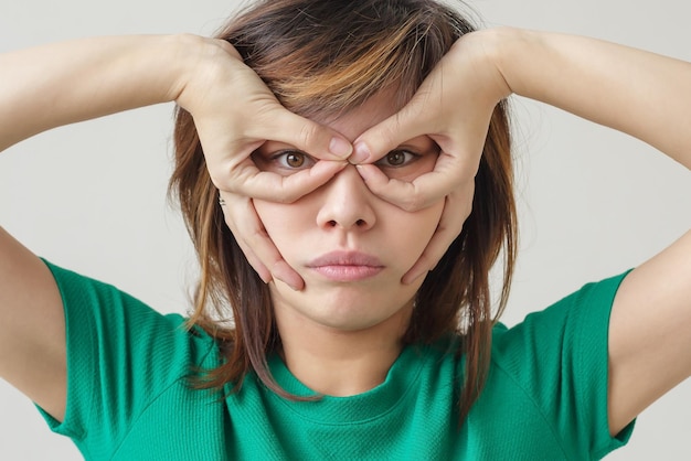 Foto ragazza asiatica che si tiene per mano come maschera da super eroe