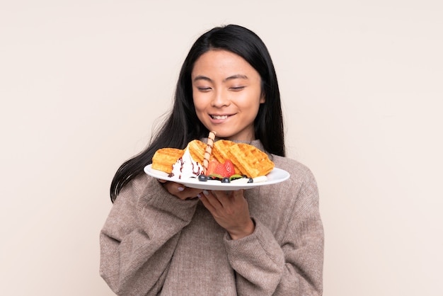 Photo asian girl holding a plate of waffles