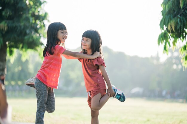 アジアの女の子は朝、公園でジョギングしています