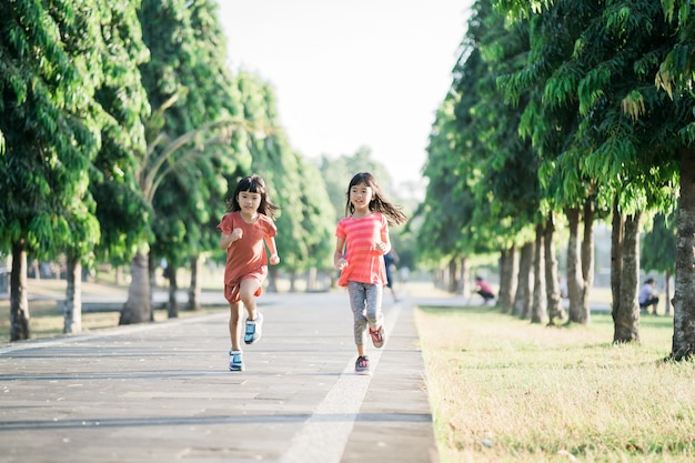 アジアの女の子は朝、公園でジョギングしています