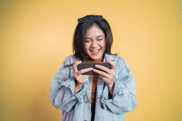 sexy Asian woman play game online on smartphone and smile Stock Photo