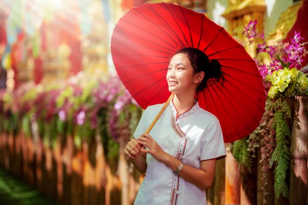 Asian girl in northern traditional costume and red umbrella