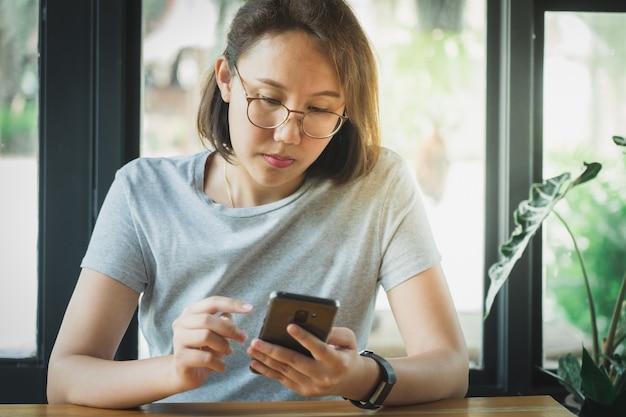 Asian girl Play smartphone For entertainment and work outside the office or outside. 