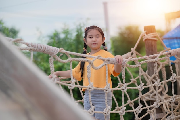 Ragazza asiatica che gioca nel parco giochi felice bambina asiatica divertendosi a giocare nel parco giochi