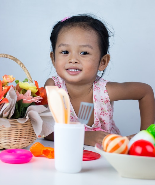 Asian girl playing toy cooking.