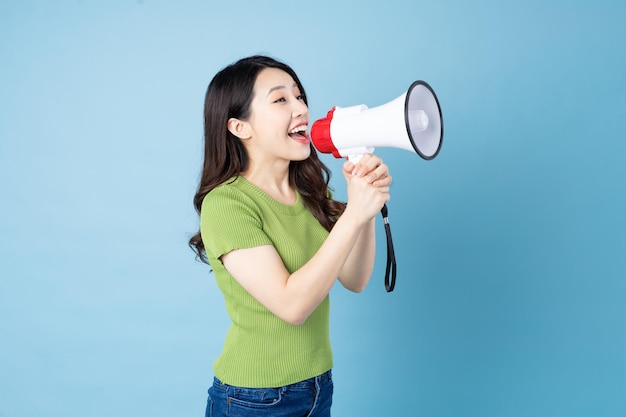 Asian girl portrait holding speaker, isolated on blue background