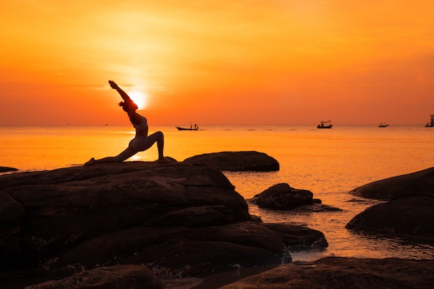 Photo asian girl practice yoga on the beach sunrise morning day