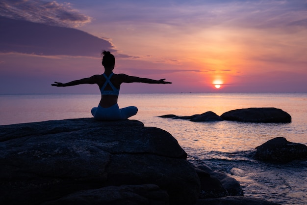 Asian girl practice Yoga on the beach Sunrise morning day