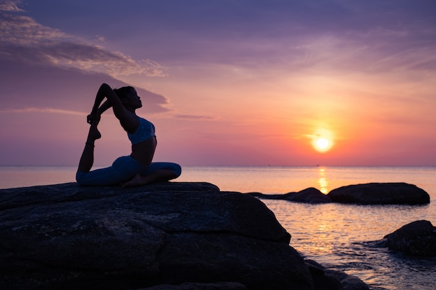 Asian girl practice Yoga on the beach Sunrise morning day