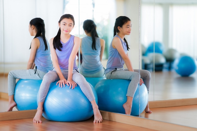 Asian girl sit on a ball and relax before exercise