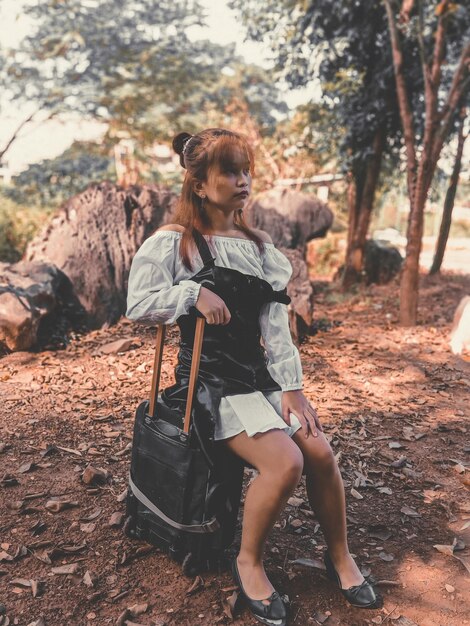 Asian girl sitting on a traveling bag feeling lost autumn cinematic fastasy