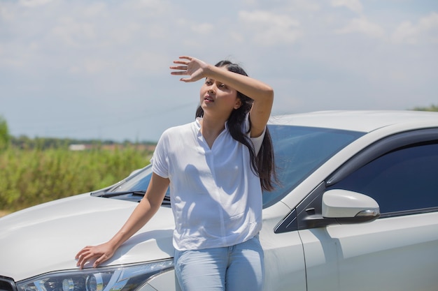 通りの車に立っているアジアの女の子