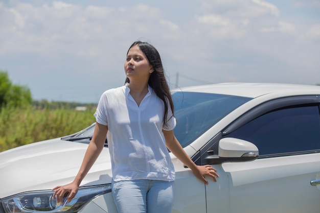 通りの車に立っているアジアの女の子