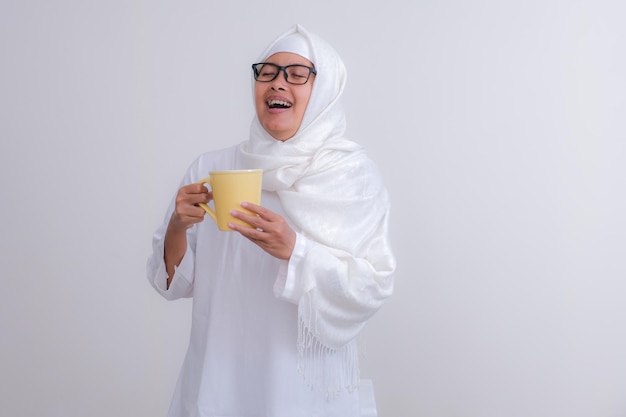 Photo asian girl standing and drinking water to break her fast during ramadan month