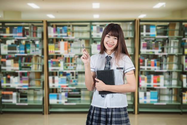 Asian girl student in school japan uniform on library background