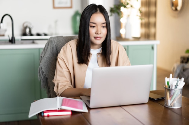 Asian girl studying at home distance education concept female student learning with laptop young wom...