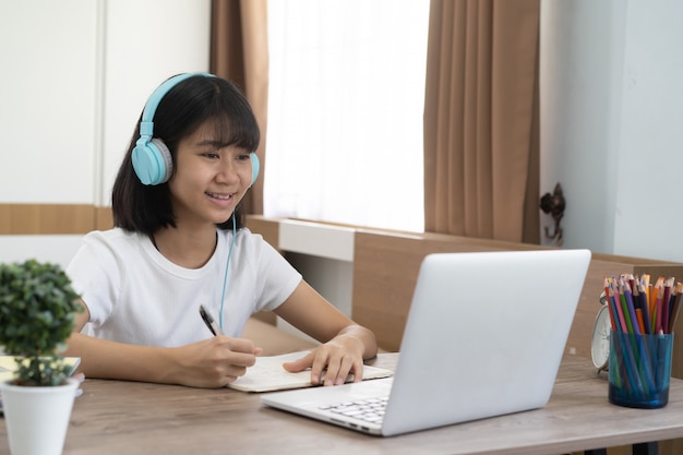 Ragazza asiatica che studia lezione online di compiti a casa, istruzione online a distanza sociale