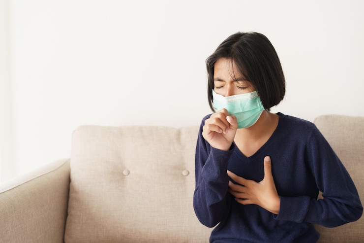 Photo asian girl symptom cough and are protective with medical mask while sitting on sofa, asia child wearing a protection mask epidemic of flu or covid-19 in living room at home. health and illness concept