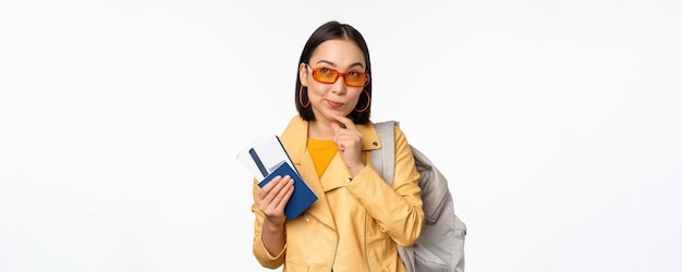 Asian girl tourist with boarding tickets and passport going abroad holding backpack thinking of trav